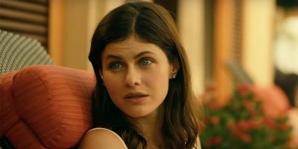 Rachel Patton (Alexandra Daddario) sitting on a pool chair at the resort on The White Lotus, talking to someone.